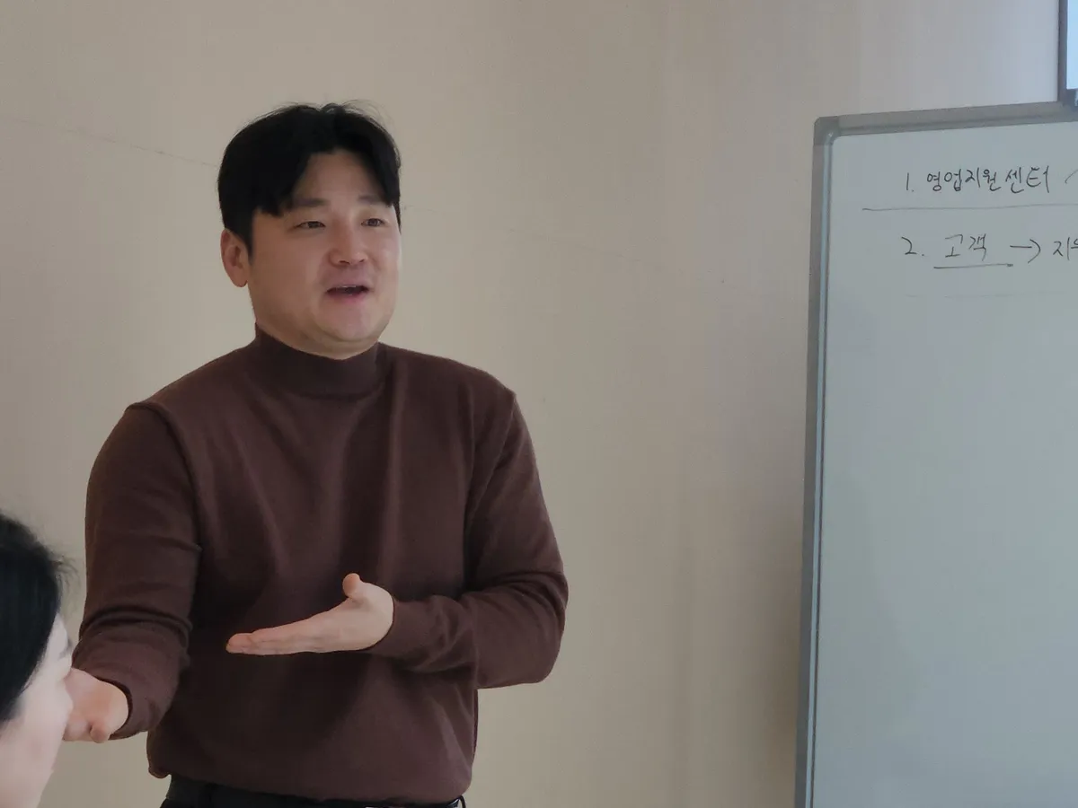 신입 교육에서 강사가 손짓으로 상담 흐름을 설명하는 모습