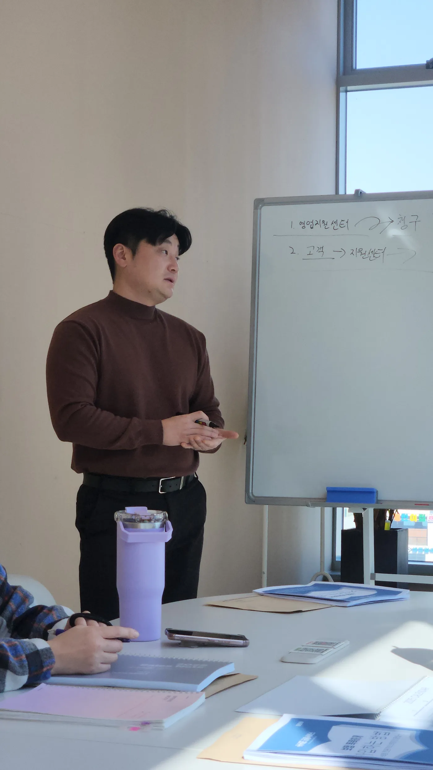 화이트보드 앞에서 상품 내용을 설명하는 강의 모습